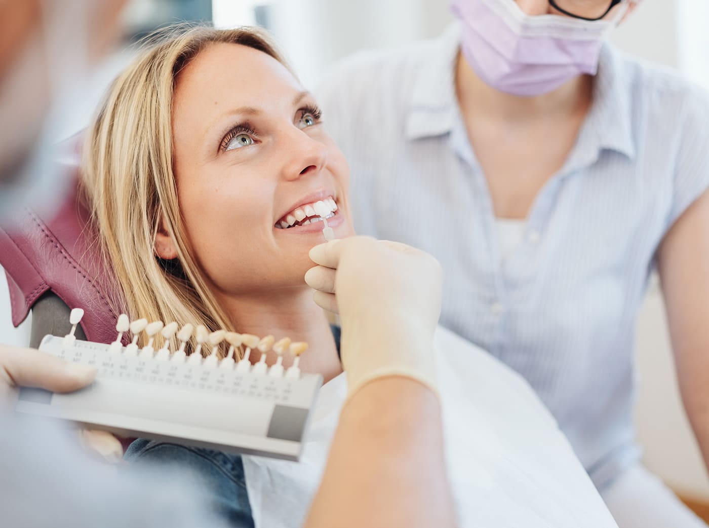 Dentist checking the whiteness of a patients teeth