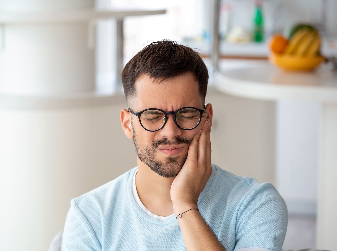 Young man suffering from tooth pain, caries. Male suffering from toothache, closeup. Portrait of casual man toothache with painful expression
